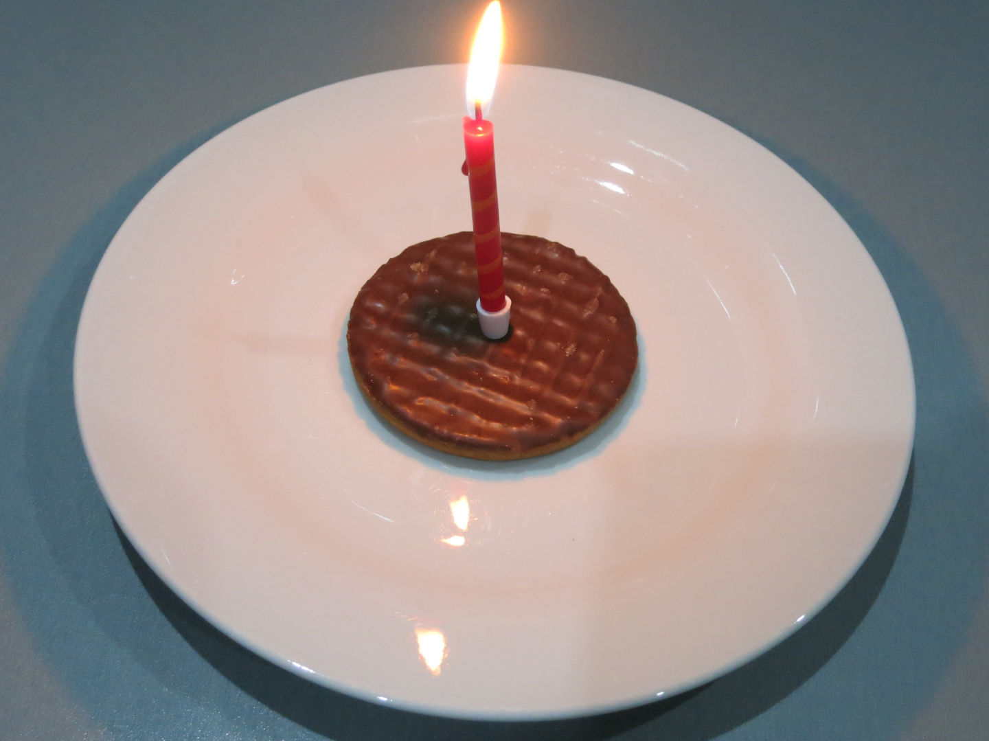 A picture of a biscuit with a candle.