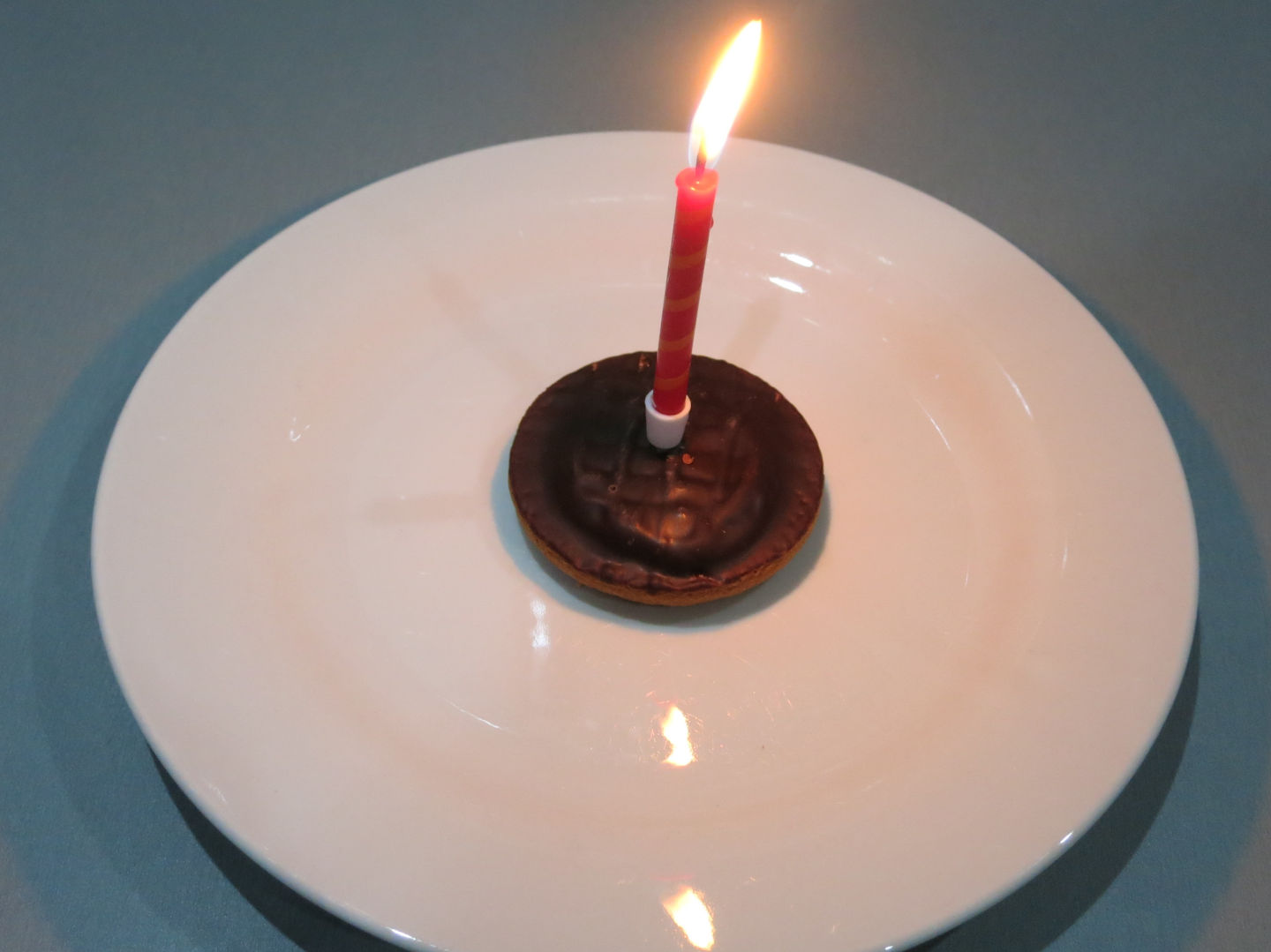 A picture of a JaffaCake with a candle.